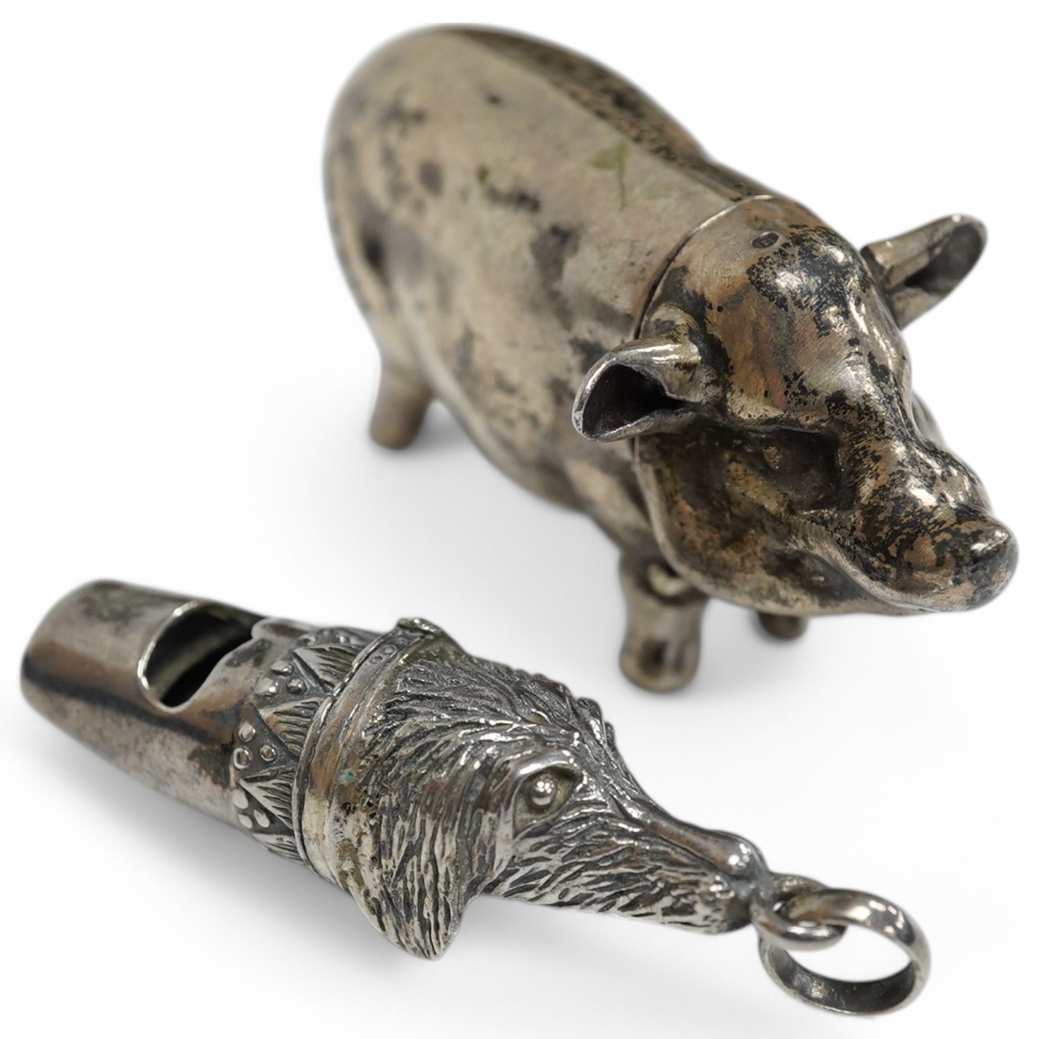 A modern silver novelty vesta case modelled as a pig, by David A. Bowles, London, 1902, 62mm, together with a novelty sterling whistle modelled as a dog's head. Condition - fair to good